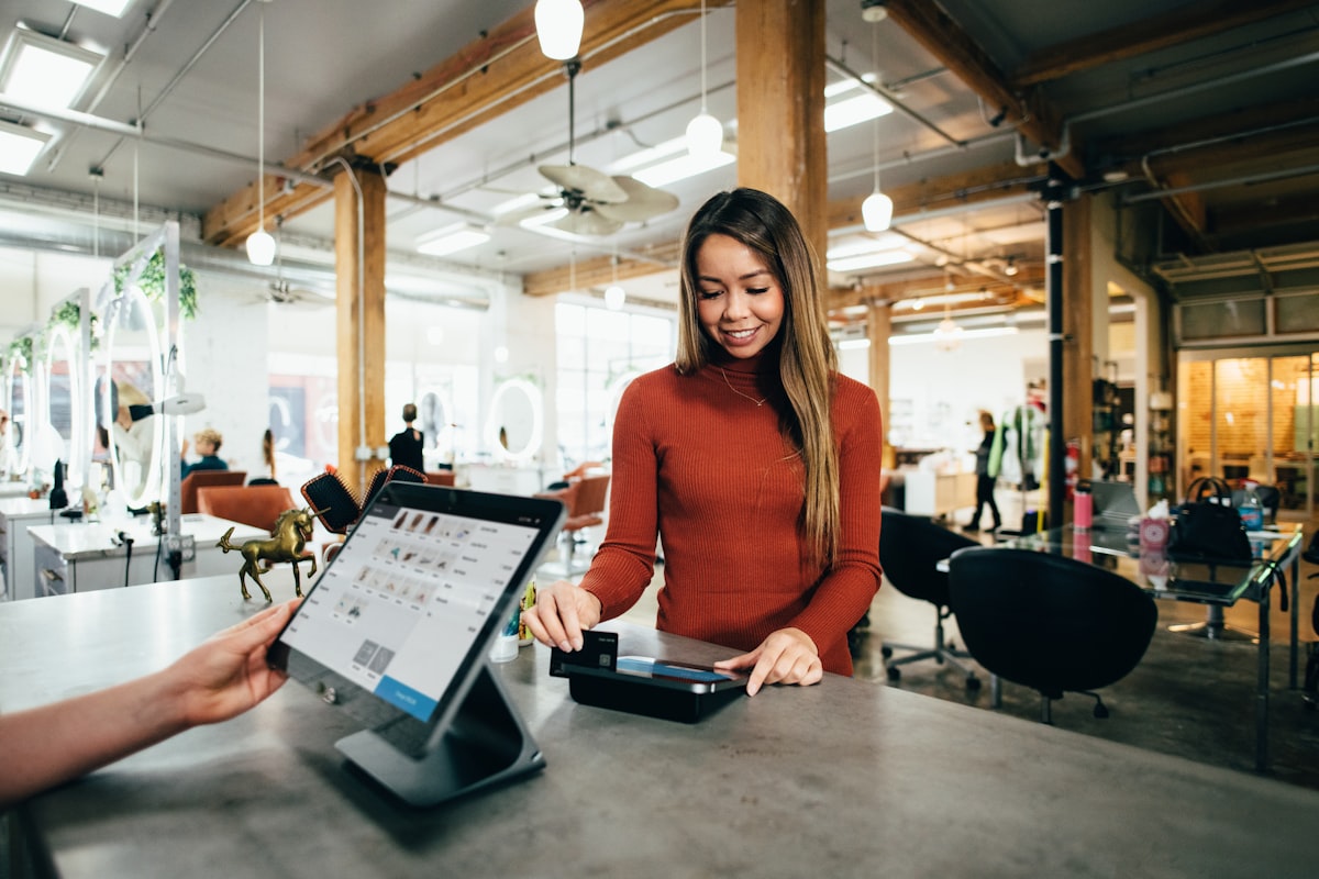 Salon owner taking a client payment at the front desk